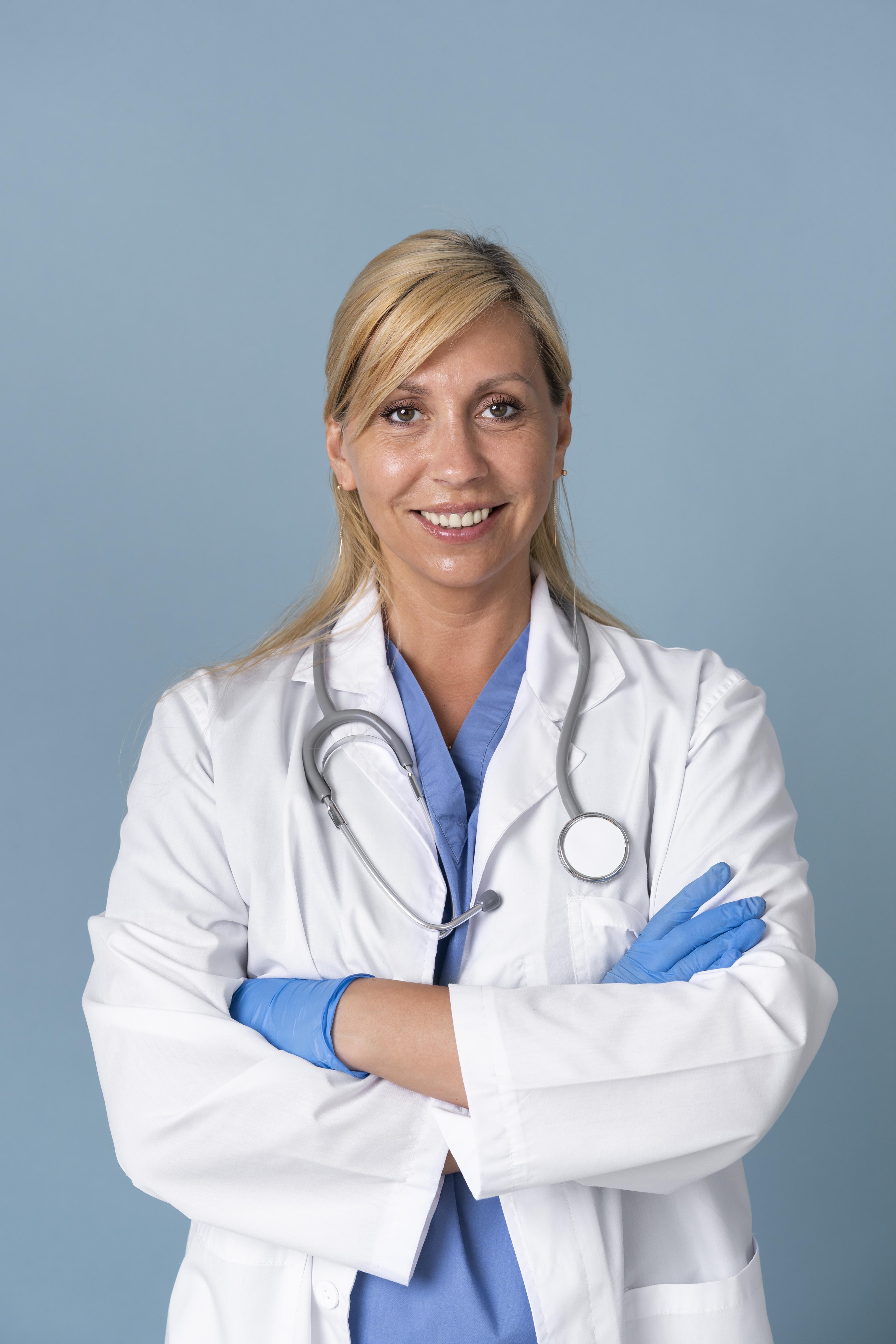Smiley female doctor posing in suit and stethoscope freepik